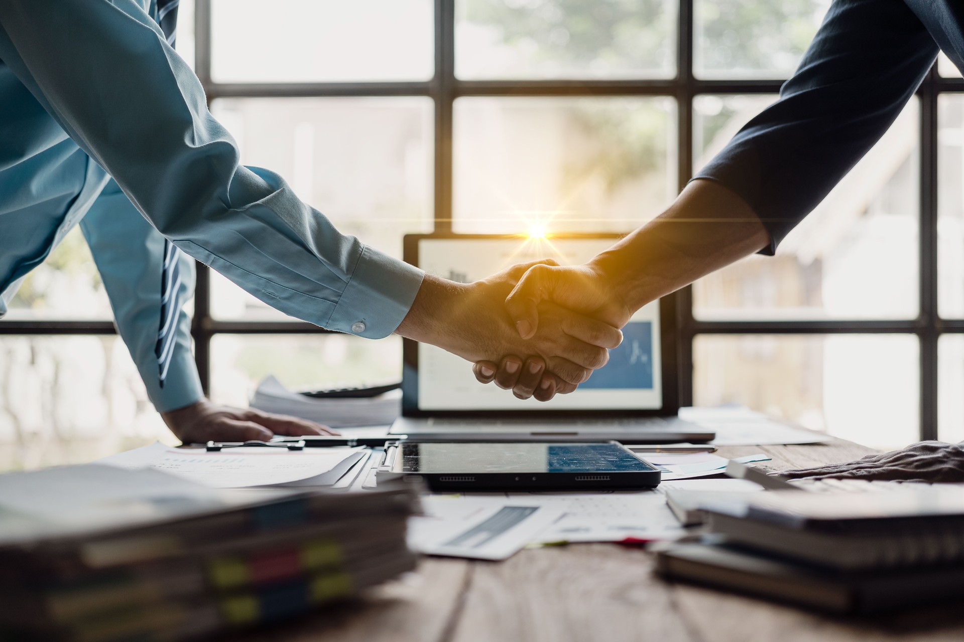Businessmen shaking hands with sales reports and analysis documents shaking hands while coming to a mutual agreement after negotiations.
Close-up pictures